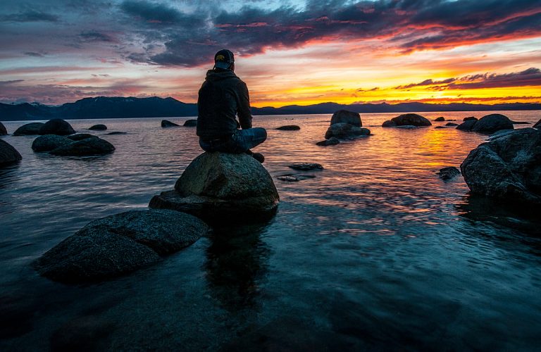 person-sitting-on-rock-on-body-of-water-1478685